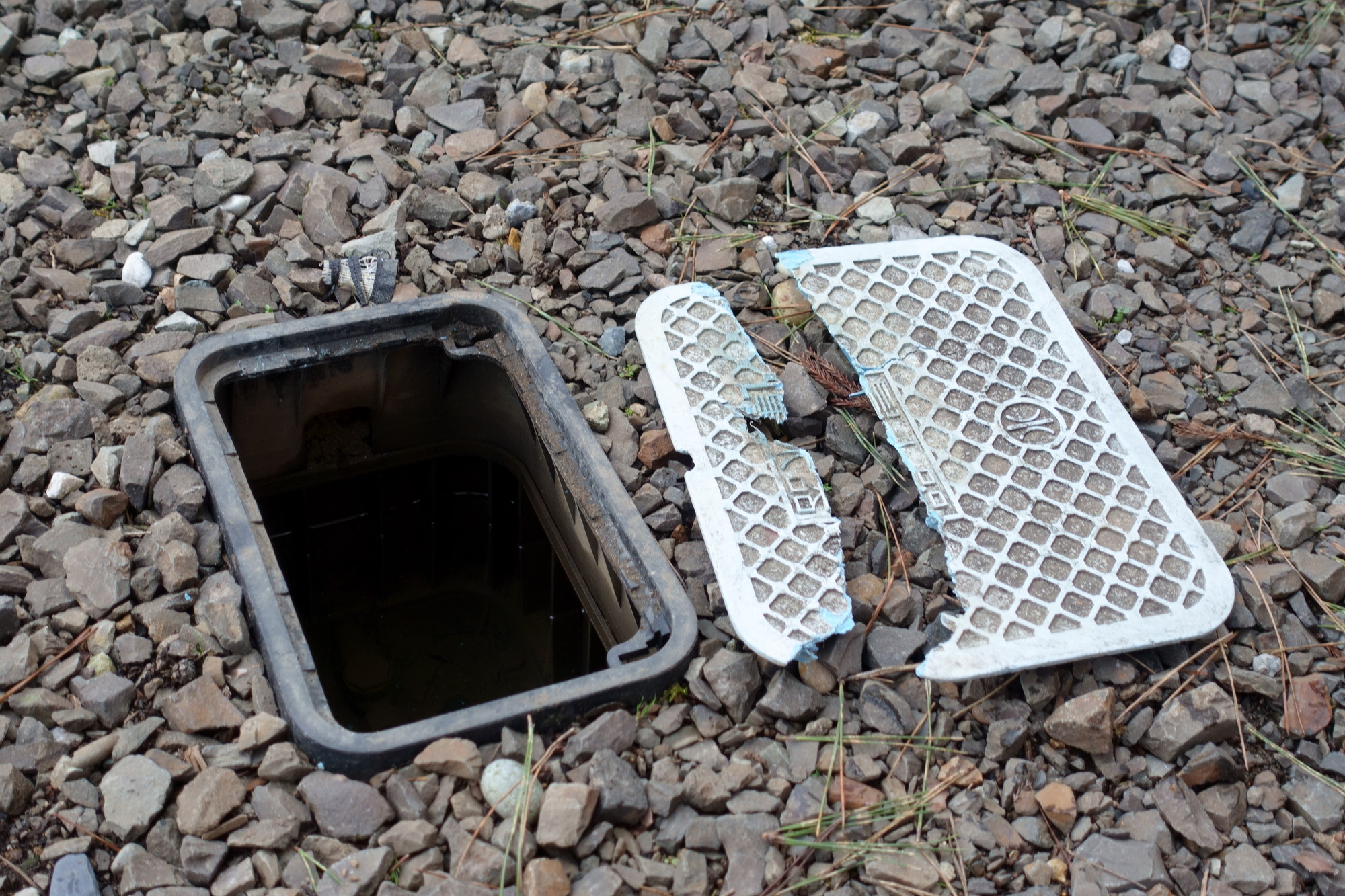 割れた水道メーターの蓋を外した様子